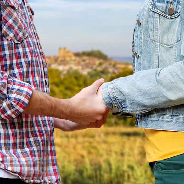 Couple se tenant la main avec la ville de Gourdon en arrière plan